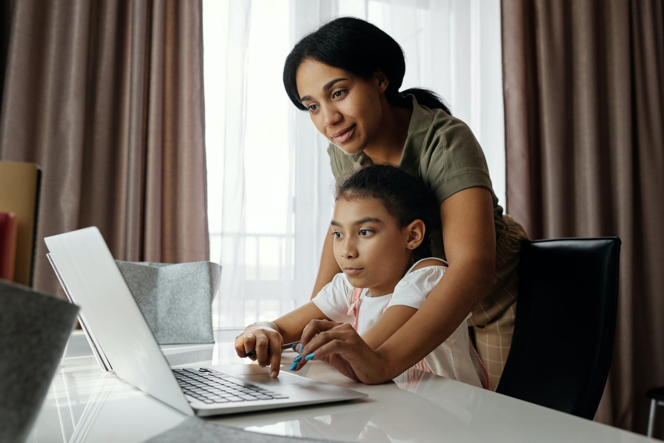 A mother helps her daughter learn about investment accounts for kids