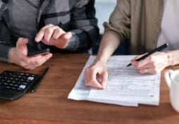 Two People Doing Paperwork and Computing Taxes