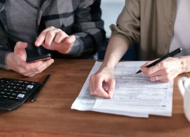 Two People Doing Paperwork and Computing Taxes