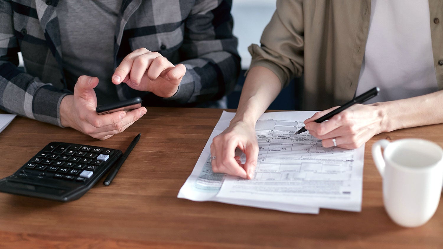 Two People Doing Paperwork and Computing Taxes