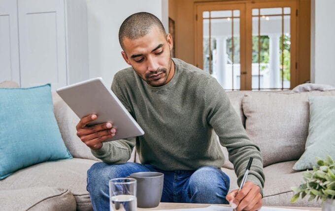 A man in his living room looking over his personal finances.