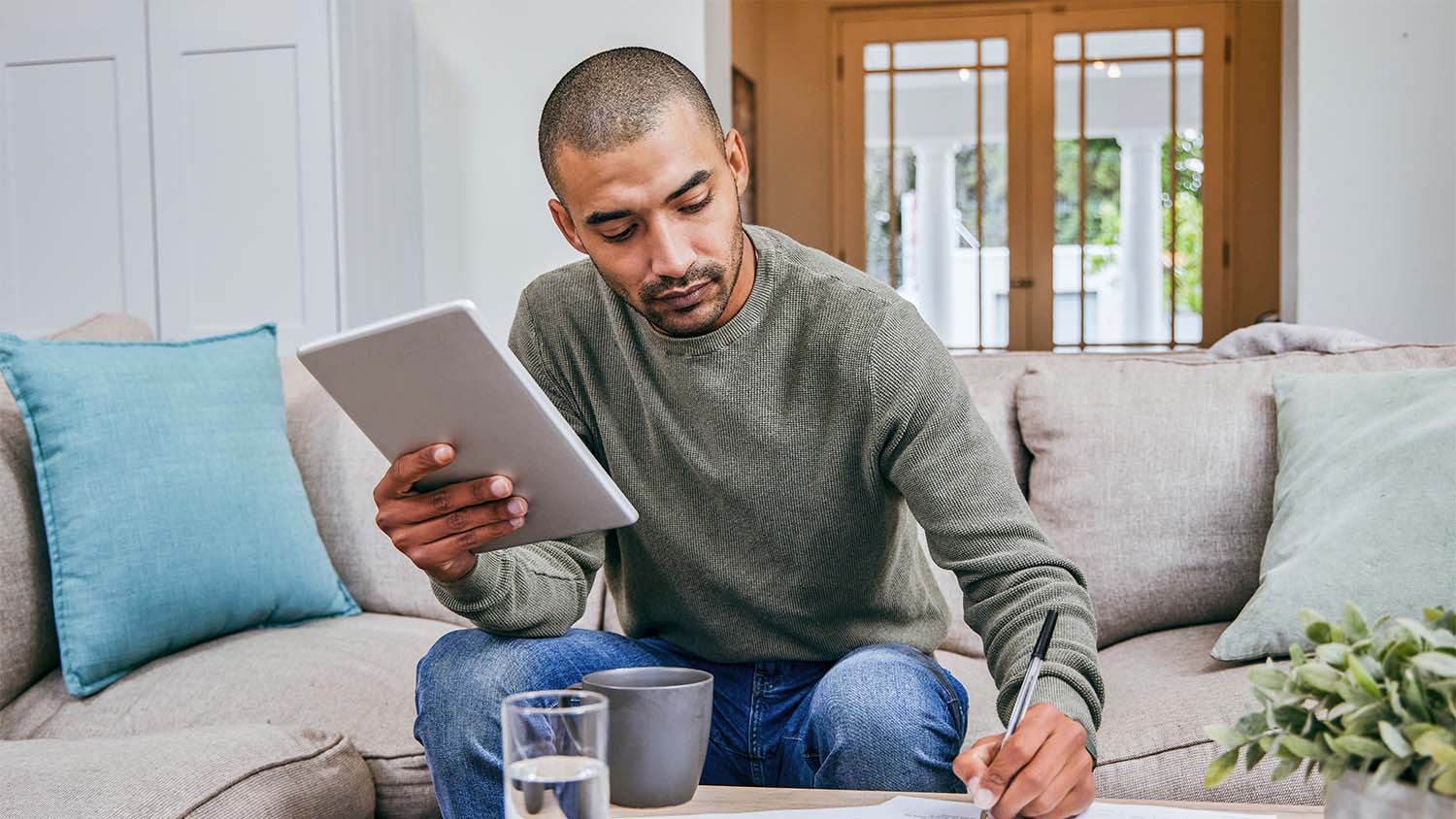 A man in his living room looking over his personal finances.